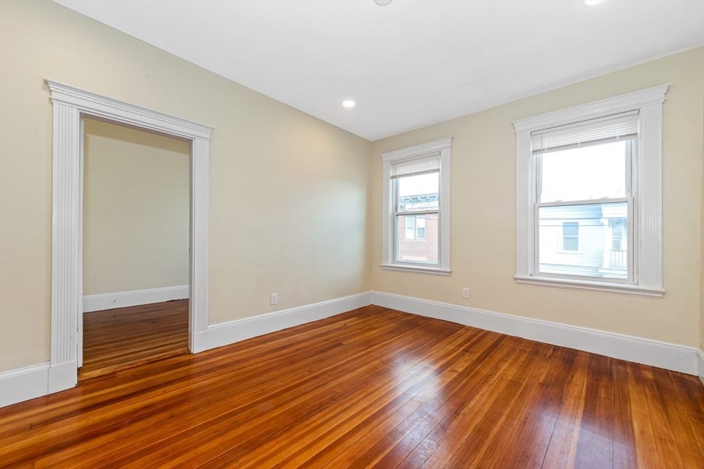 44 Brackett Street, Unit 3 Boston, MA 02135 - Photo 12 of 27 an empty room with wooden floor and windows