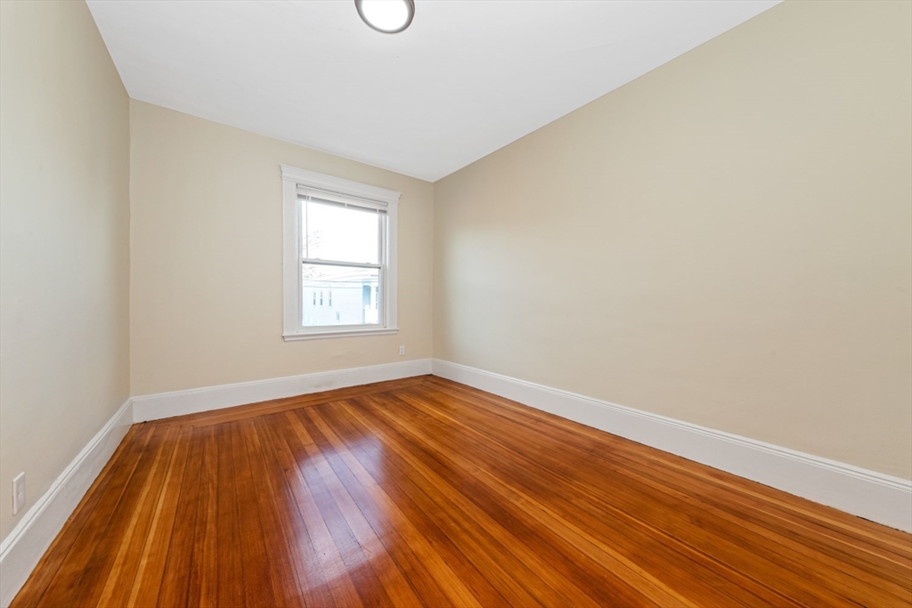 44 Brackett Street, Unit 3 Boston, MA 02135 - Photo 16 of 27 an empty room with wooden floor and windows