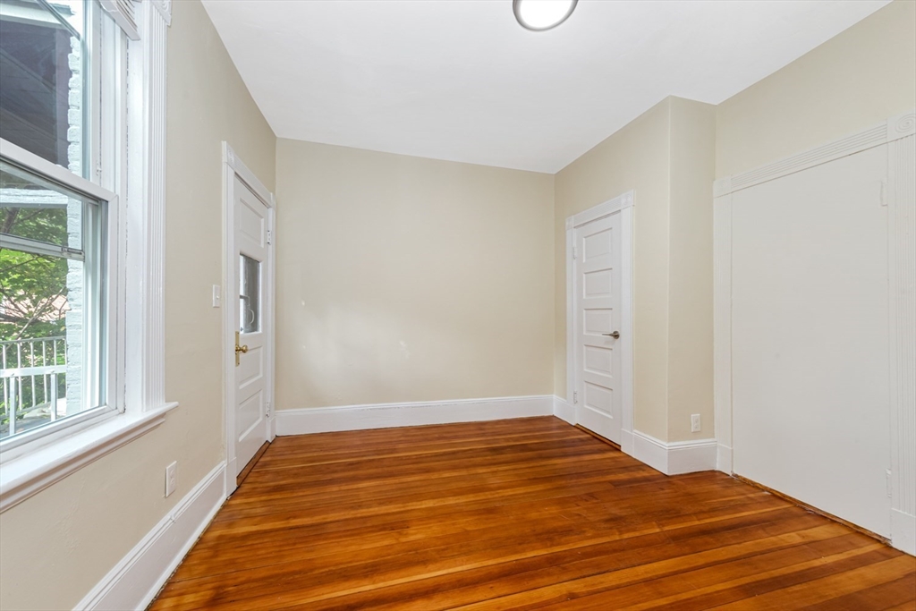44 Brackett Street, Unit 3 Boston, MA 02135 - Photo 21 of 27 a view of a room with wooden floor and white walls