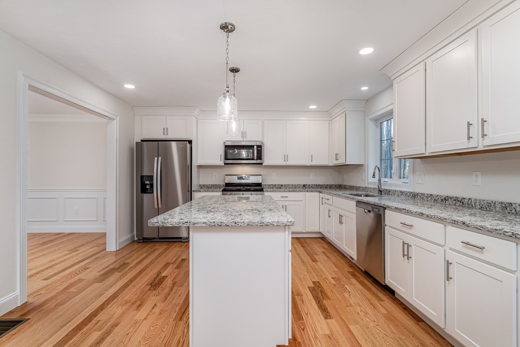 512 Northfield Road Lunenburg, MA 01462 - Photo 14 of 33 a kitchen with stainless steel appliances granite countertop a sink dishwasher a refrigerator and white cabinets with wooden floor