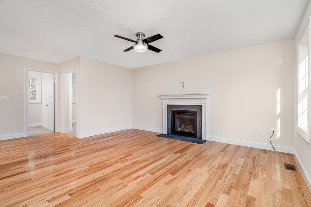 512 Northfield Road Lunenburg, MA 01462 - Photo 3 of 33 a view of empty room with wooden floor and fireplace