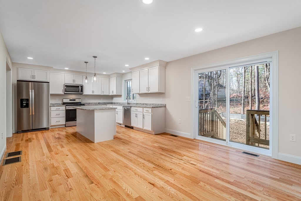 512 Northfield Road Lunenburg, MA 01462 - Photo 7 of 33 a large kitchen with stainless steel appliances kitchen island a large counter top and wooden floors
