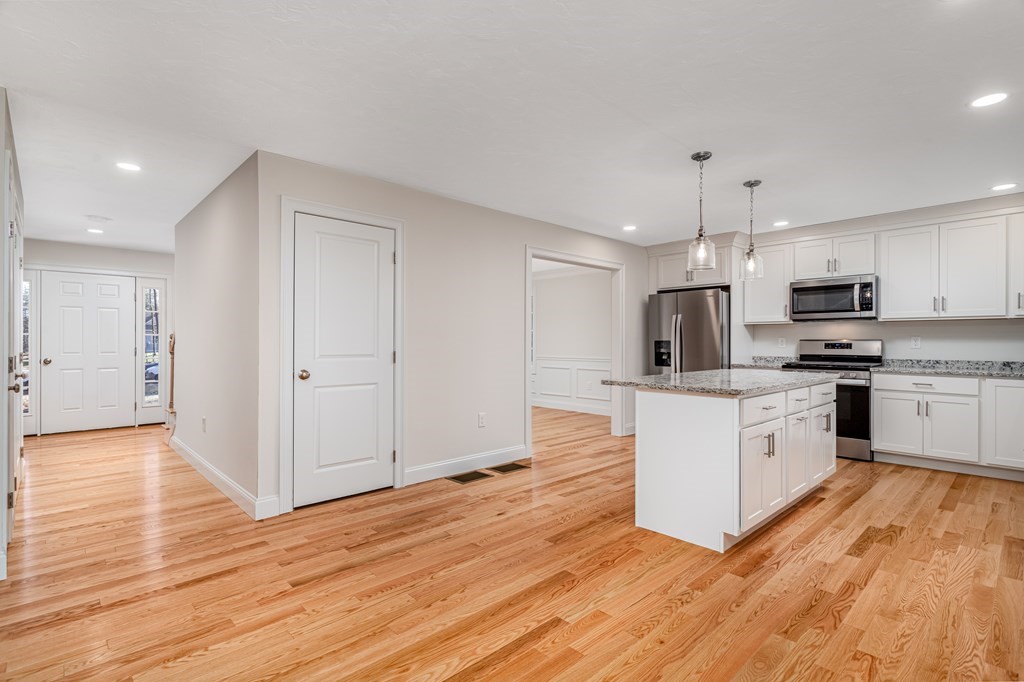 512 Northfield Road Lunenburg, MA 01462 - Photo 8 of 33 a kitchen with white cabinets stainless steel appliances and wooden floor