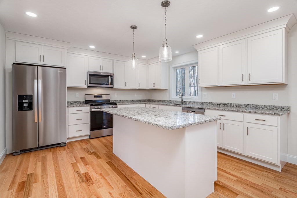 512 Northfield Road Lunenburg, MA 01462 - Photo 10 of 33 a kitchen with stainless steel appliances granite countertop a sink a stove a refrigerator and island with wooden floor