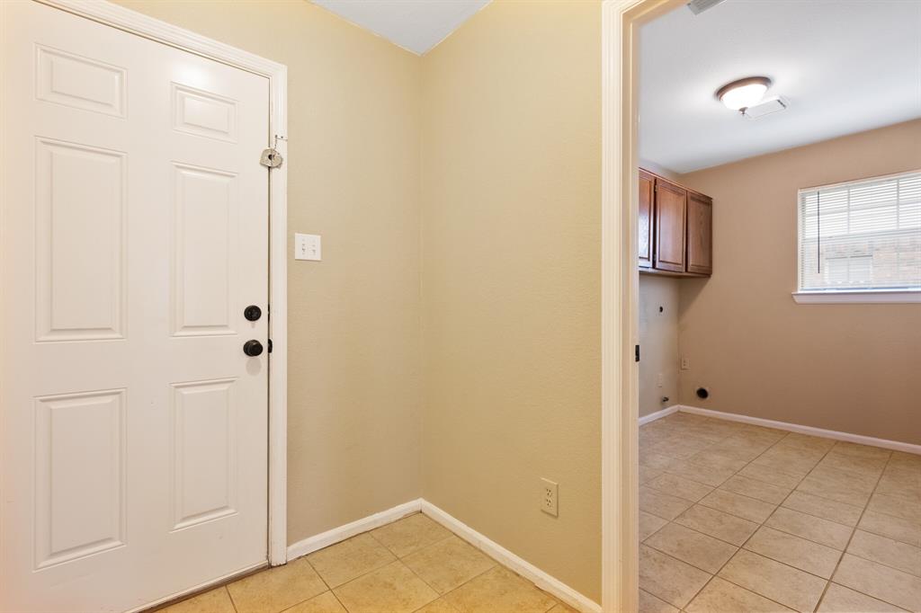 7517 Point Reyes Drive Fort Worth, TX 76137 - Photo 16 of 30 Entryway featuring a paneled door with black hardware, ceramic tile flooring, and light beige wall paint