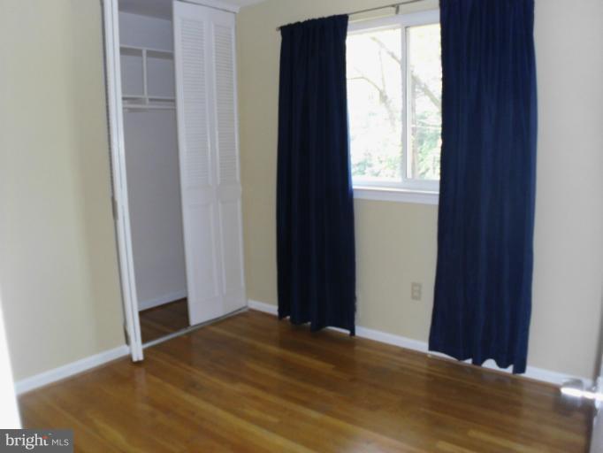 5511 Rolling Road Springfield, VA 22151 - Photo 4 of 17 a view of a bedroom with wooden floor and windows