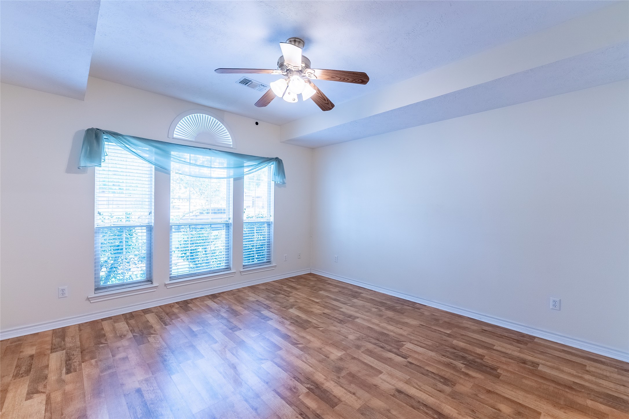 4802 Treadgold Lane Bryan, TX 77802 - Photo 12 of 27 an empty room with wooden floor fan and windows