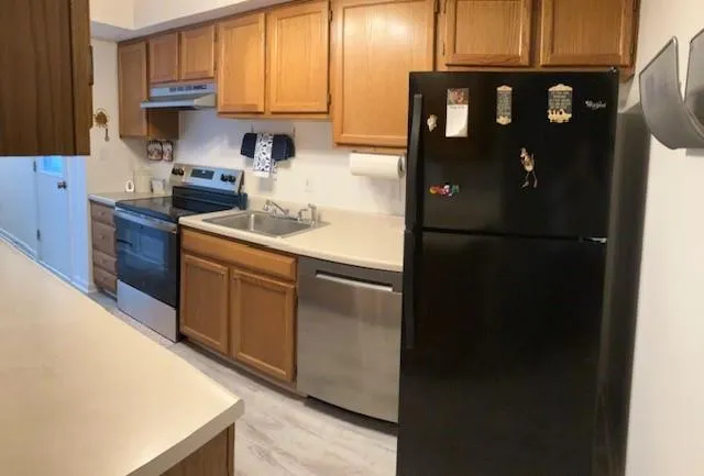 a kitchen with stainless steel appliances granite countertop a refrigerator a stove a sink and a microwave