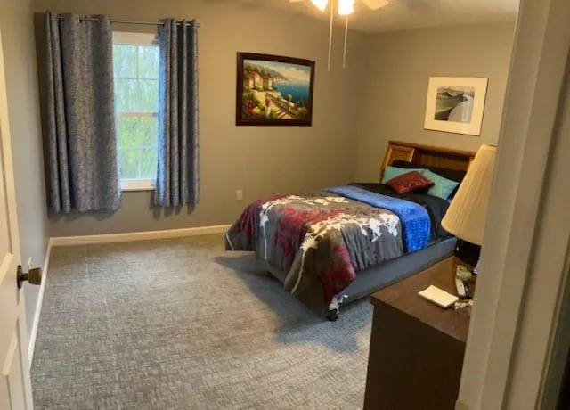 a bed sitting in a bedroom next to a window