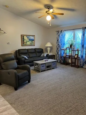 a living room with furniture a chandelier and a flat screen tv