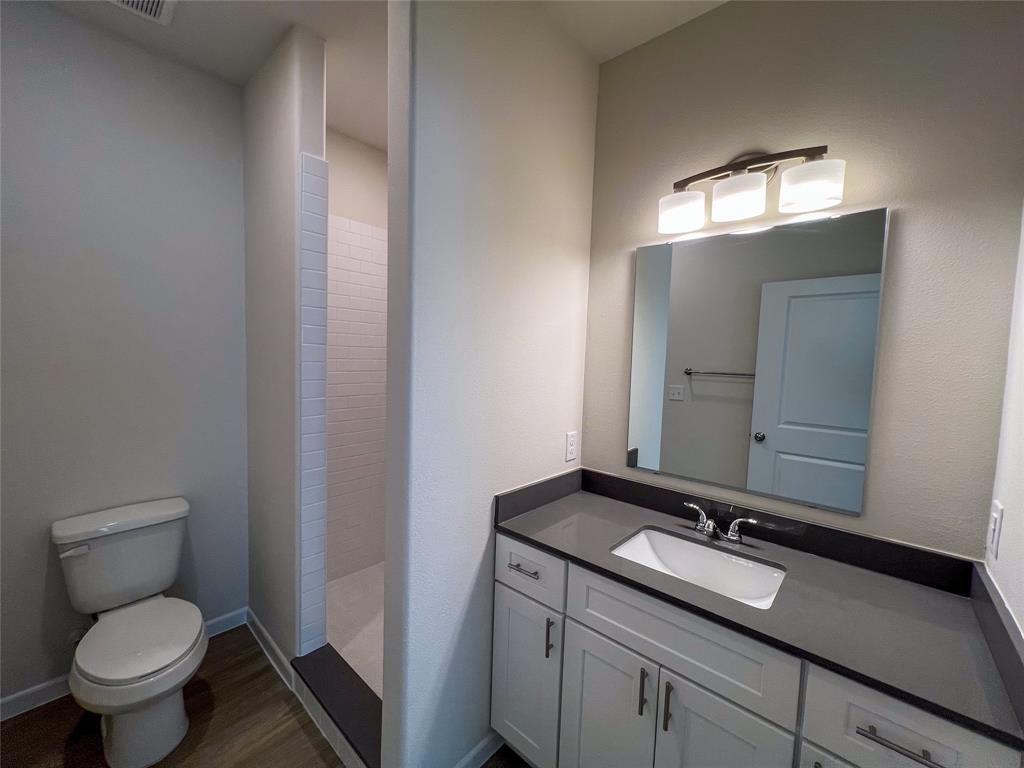 3050 Viking Street Denison, TX 75020 - Photo 13 of 17 a bathroom with a toilet sink and mirror