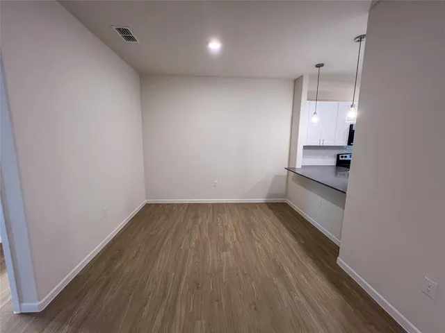 an empty room with a window and wooden floor