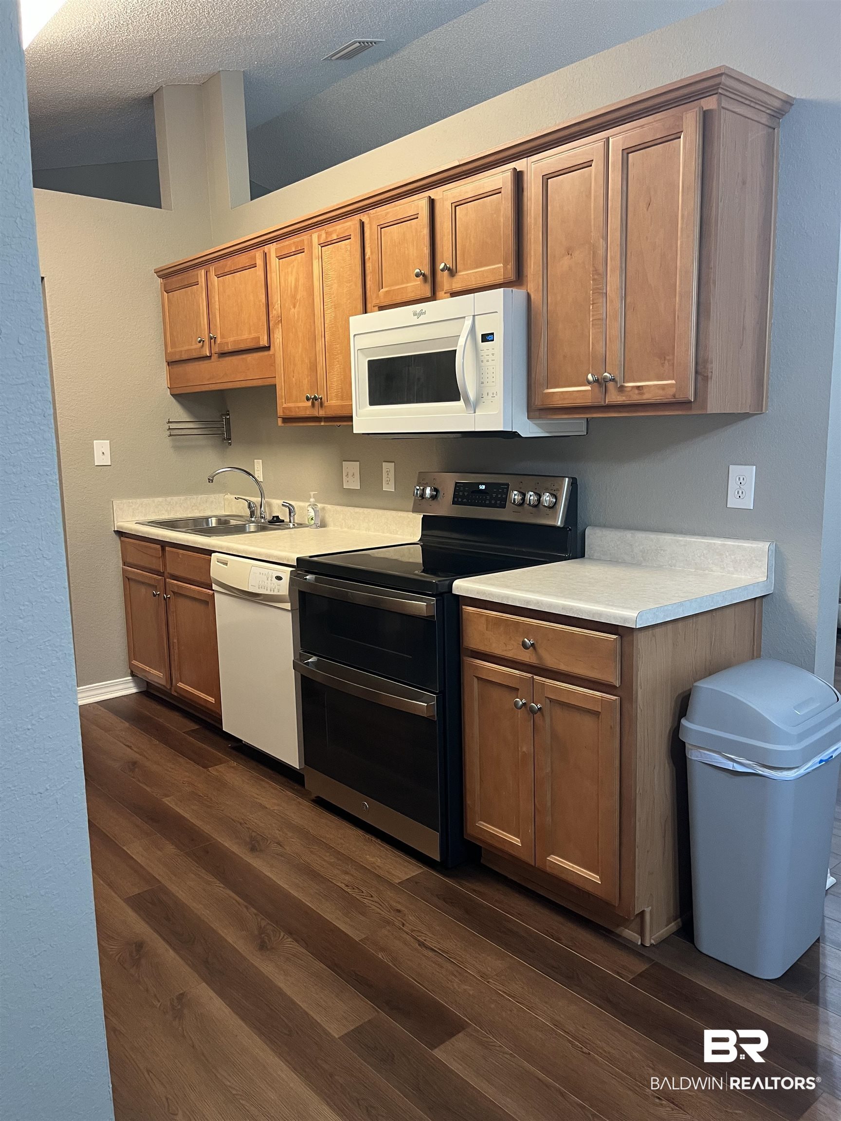 309 Cluster Street Foley, AL 36535 - Photo 3 of 38 Kitchen featuring wood-finish flooring, light wood cabinetry, white countertops, stainless steel electric range, and a white over-the-range microwave