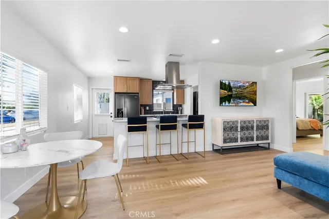 a open kitchen with stainless steel appliances kitchen island granite countertop a refrigerator and a sink