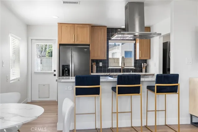a kitchen with stainless steel appliances kitchen island granite countertop a table and chairs