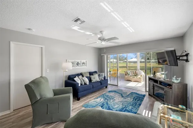 a living room with patio furniture and a floor to ceiling window