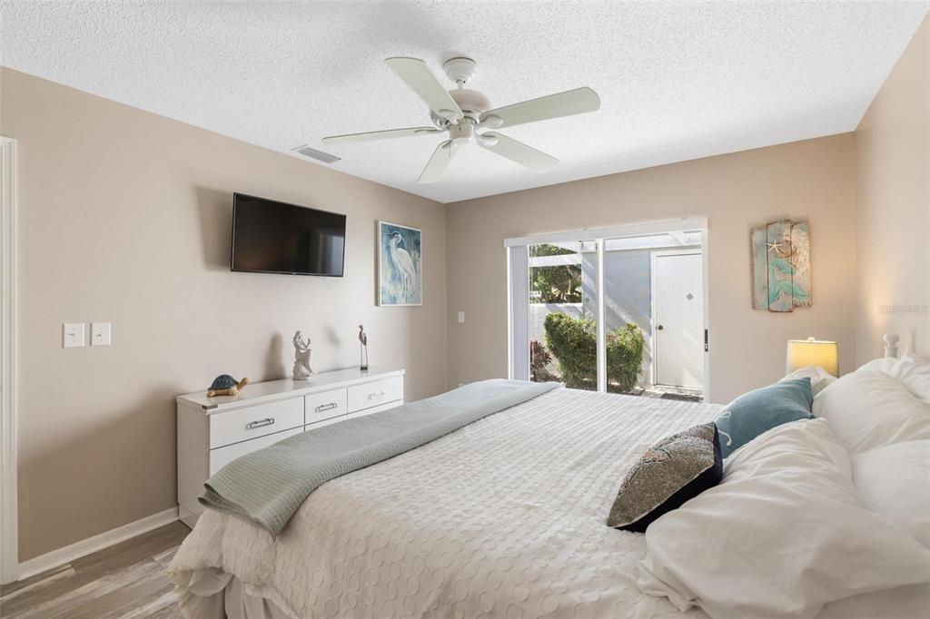 276 Cerromar Way South, Unit 60 Venice, FL 34293 - Photo 17 of 31 a bedroom with a large bed and a flat screen tv