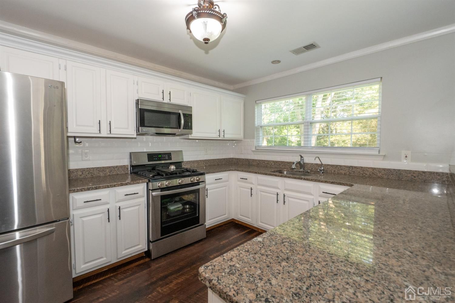 42 Springfield Road North Brunswick, NJ 08902 - Photo 16 of 37 a kitchen with granite countertop stainless steel appliances a stove microwave and sink