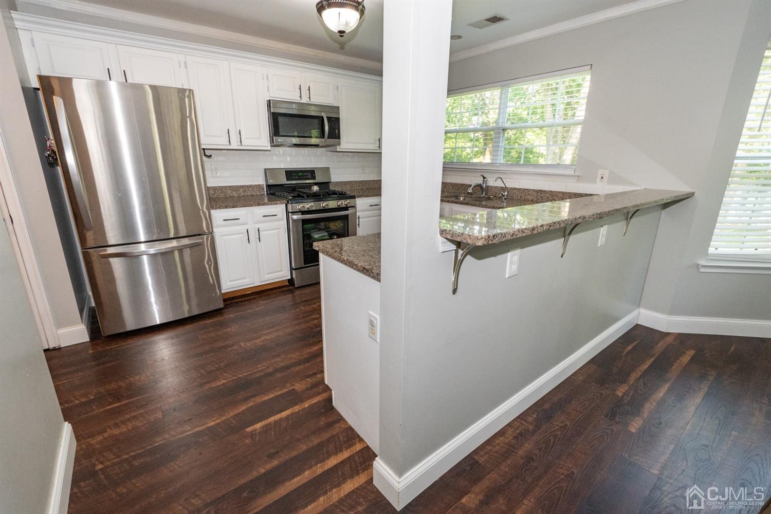 42 Springfield Road North Brunswick, NJ 08902 - Photo 18 of 37 a kitchen with wooden floors and refrigerator