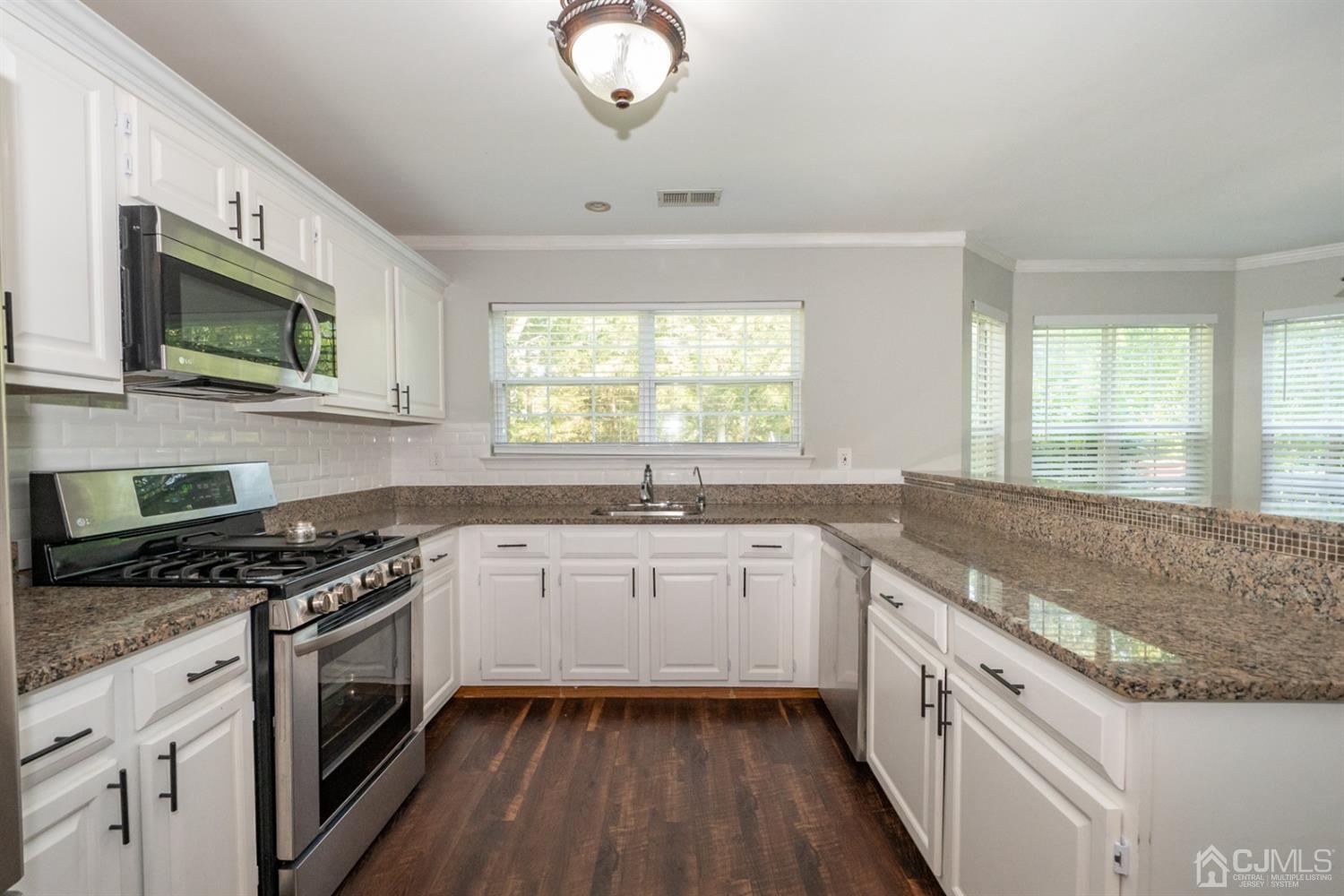 42 Springfield Road North Brunswick, NJ 08902 - Photo 4 of 37 a kitchen with stainless steel appliances granite countertop a stove a sink and a microwave