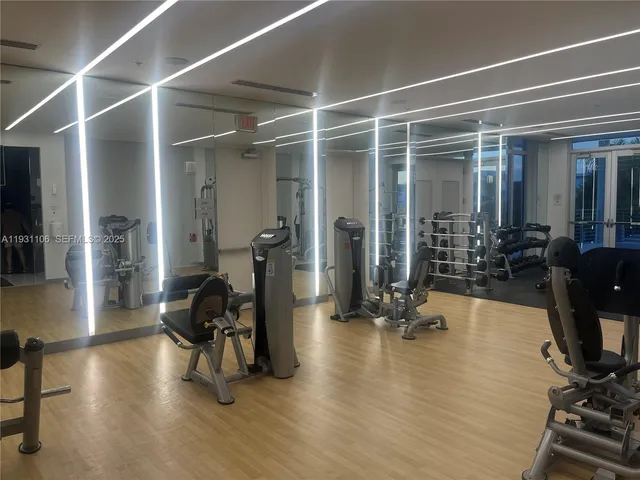 a living room with furniture gym equipment and a large window