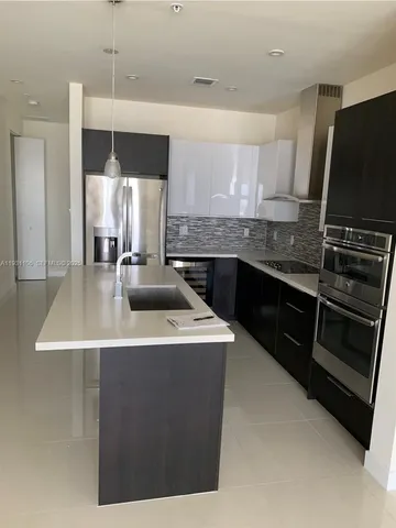 a kitchen with a stove and white cabinets