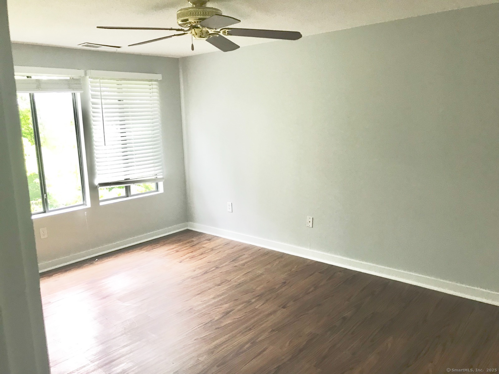 140 Shepard Avenue, Unit 140 Hamden, CT 06514 - Photo 12 of 29 an empty room with wooden floor fan and windows
