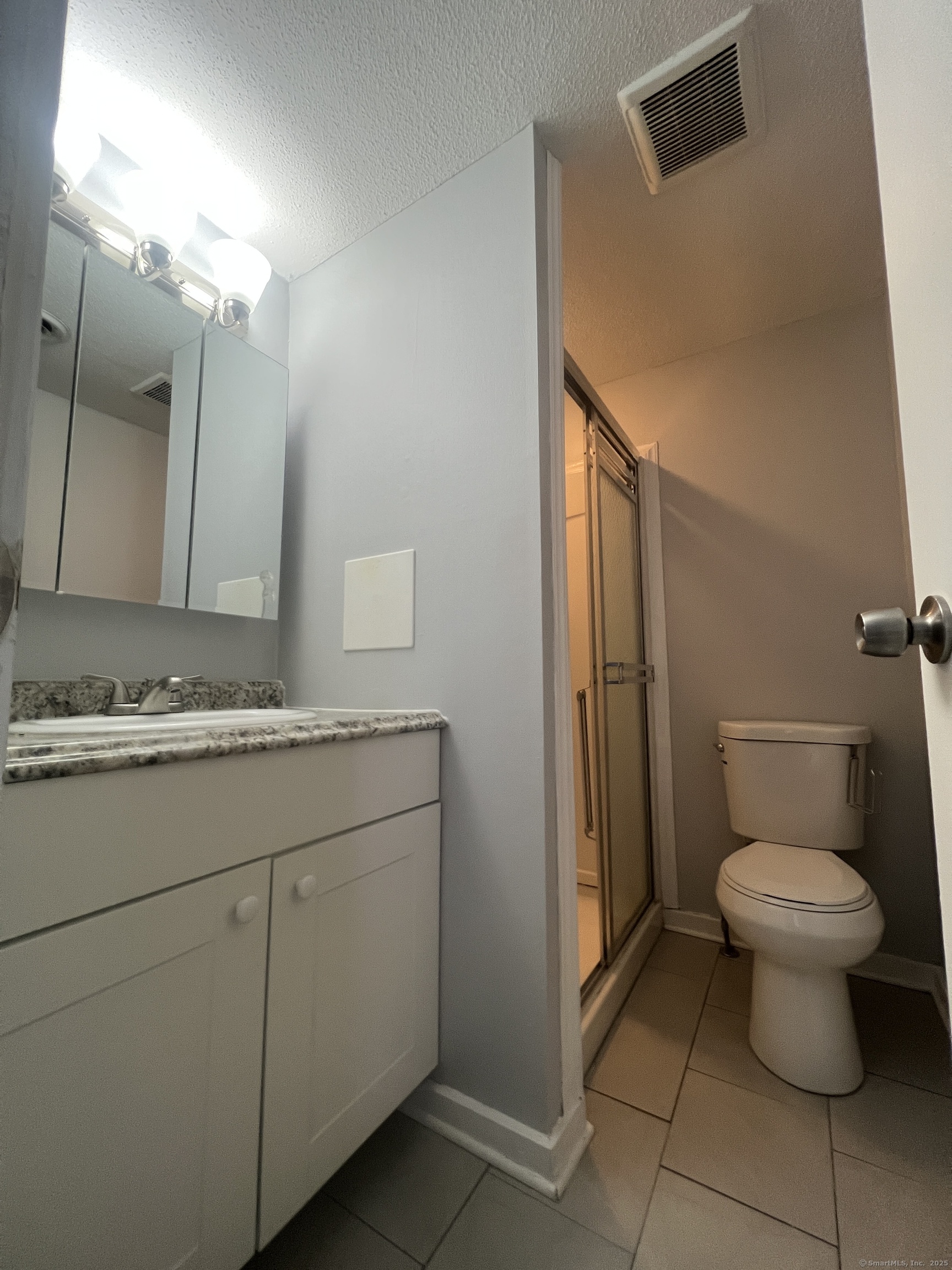140 Shepard Avenue, Unit 140 Hamden, CT 06514 - Photo 23 of 29 a bathroom with a granite countertop sink toilet and mirror
