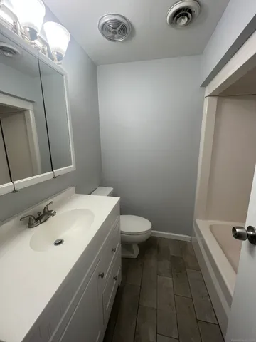 a bathroom with a sink a toilet and mirror