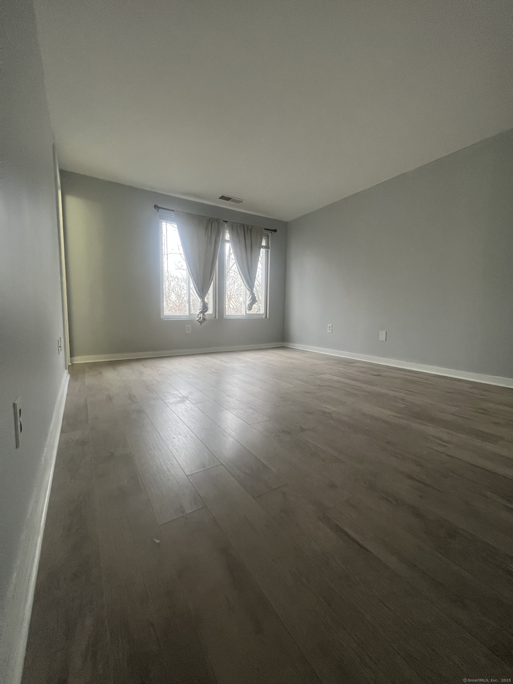 140 Shepard Avenue, Unit 140 Hamden, CT 06514 - Photo 9 of 29 an empty room with wooden floor and windows