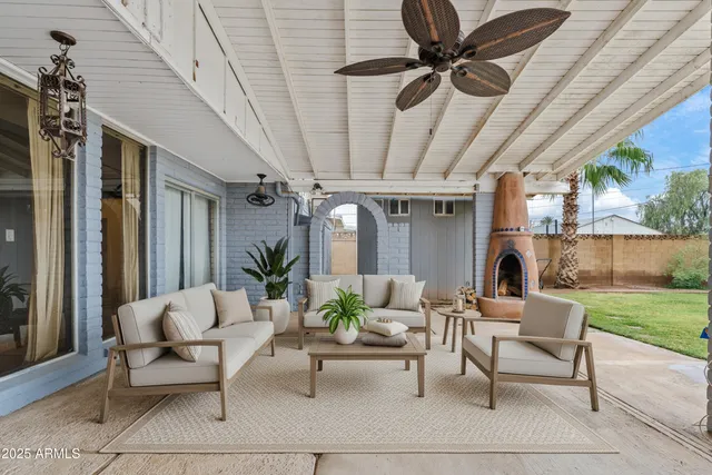 a living room with patio furniture and a garden