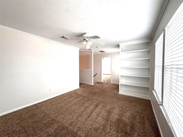 a view of a room with a ceiling fan and window