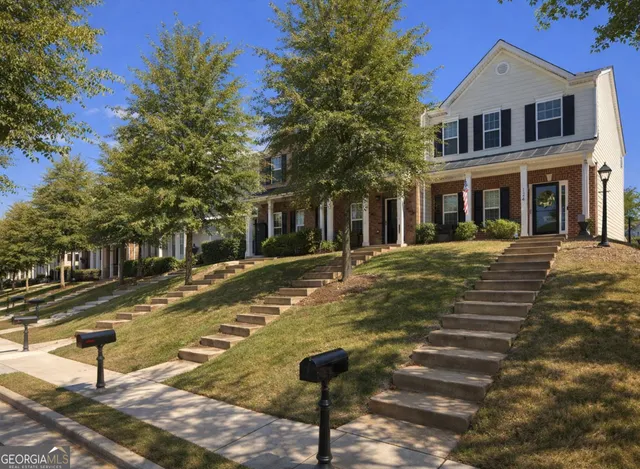 a view of a brick house with many windows next to a yard