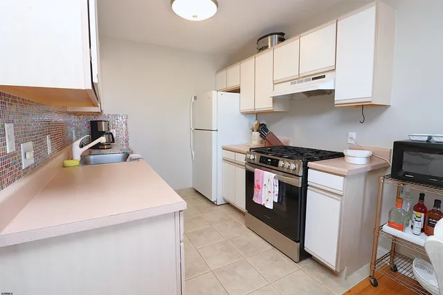 a kitchen with stainless steel appliances a stove a sink and a refrigerator