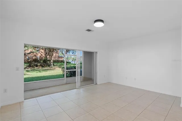 an empty room with floor to ceiling window and an outdoor view