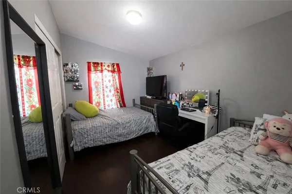 a bedroom with a bed and dresser with mirror