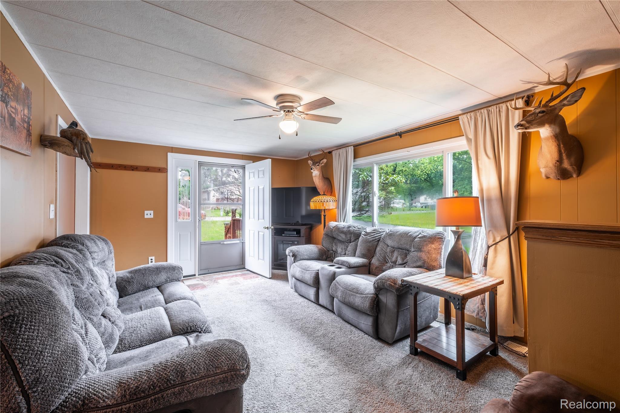 535 Snyder Road Highland, MI 48357 - Photo 16 of 23 Textured ceiling, carpeted flooring, large window, ceiling fan with integrated lighting, and a glass-paneled entry door