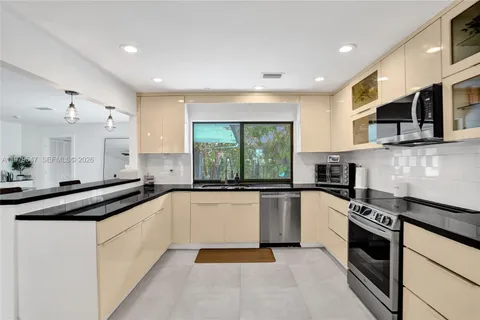 a large kitchen with stainless steel appliances granite countertop a stove and a sink