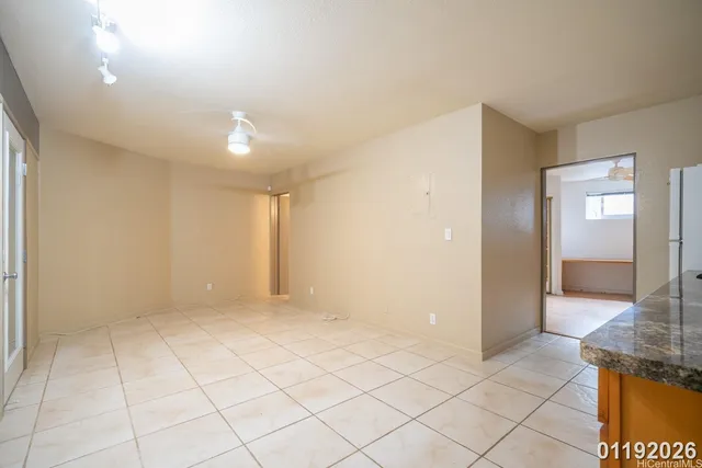 an empty room with kitchen view