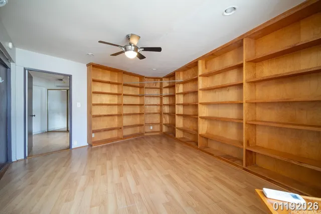 a view of a room with wooden floor and ceiling fan