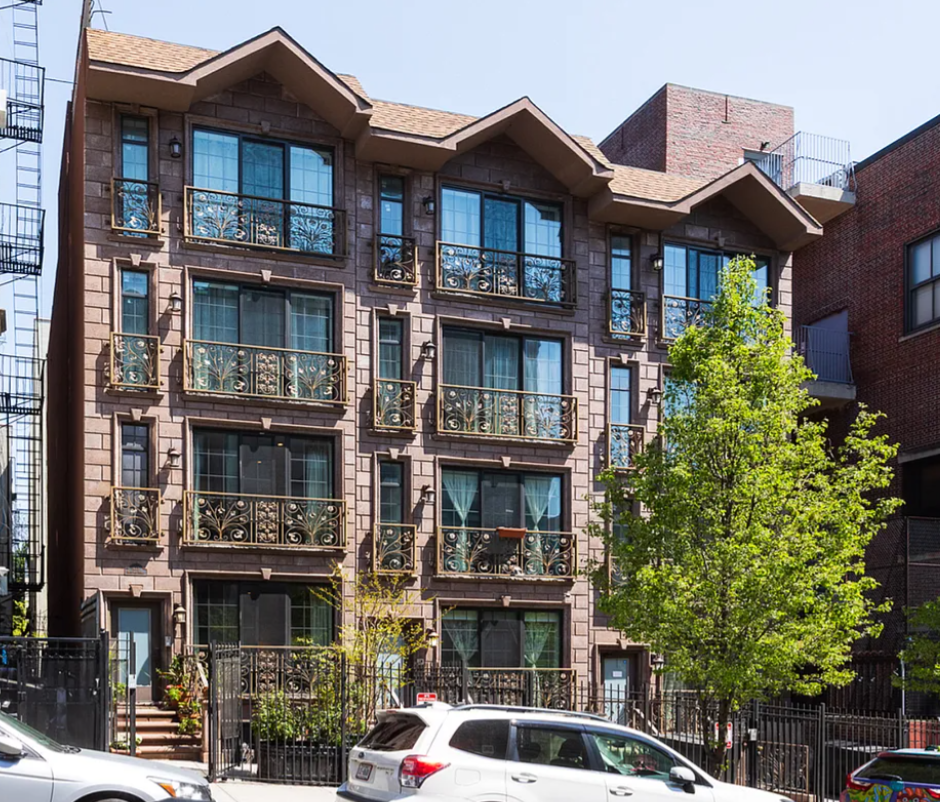 a front view of a building with a garden and plants