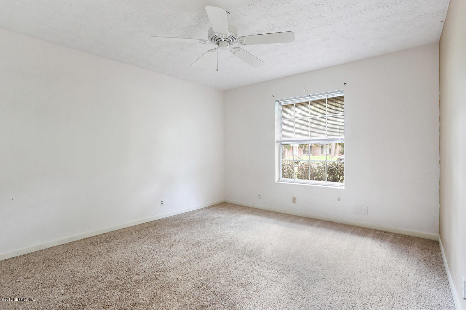 9482 Wexford Road Jacksonville, FL 32257 - Photo 20 of 25 an empty room with a window and a ceiling fan