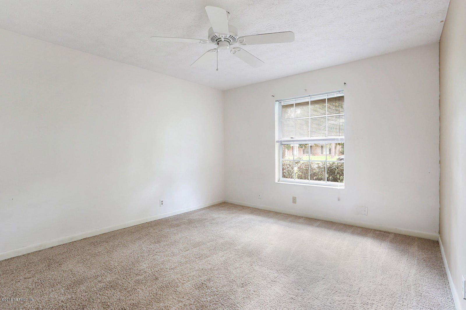 9482 Wexford Road Jacksonville, FL 32257 - Photo 21 of 25 an empty room with windows and chandelier fan