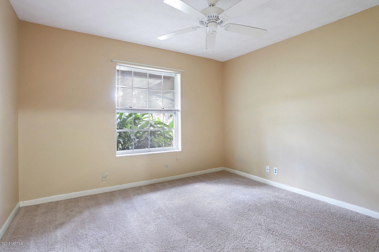 9482 Wexford Road Jacksonville, FL 32257 - Photo 22 of 25 en empty room with windows and chandelier fan