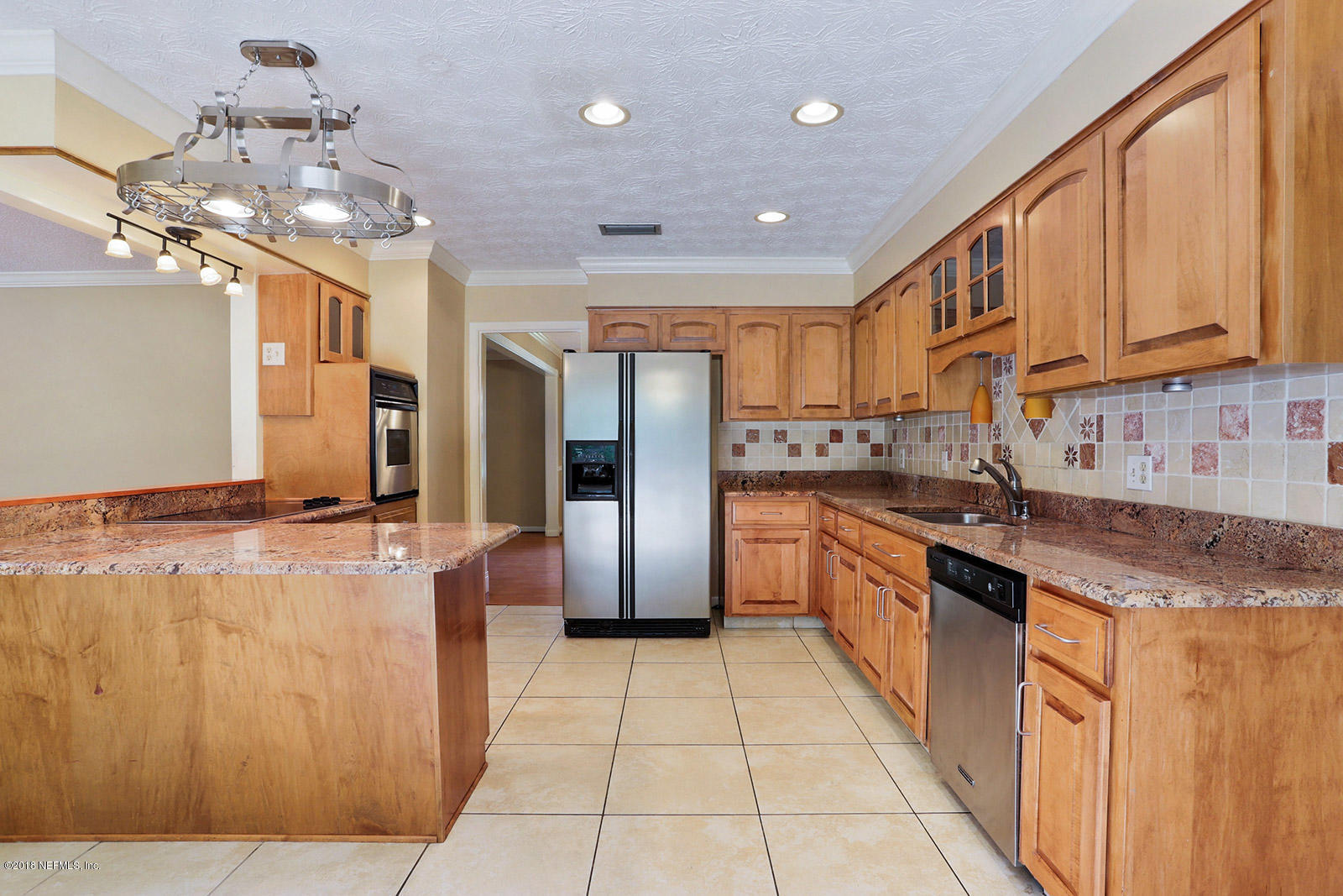 9482 Wexford Road Jacksonville, FL 32257 - Photo 7 of 25 a large kitchen with stainless steel appliances granite countertop a refrigerator a sink dishwasher a oven and a dining table with wooden floor