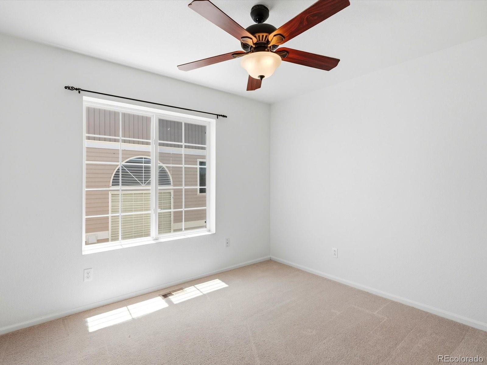 5444 Perth Court Denver, CO 80249 - Photo 36 of 46 an empty room with a window and a fan