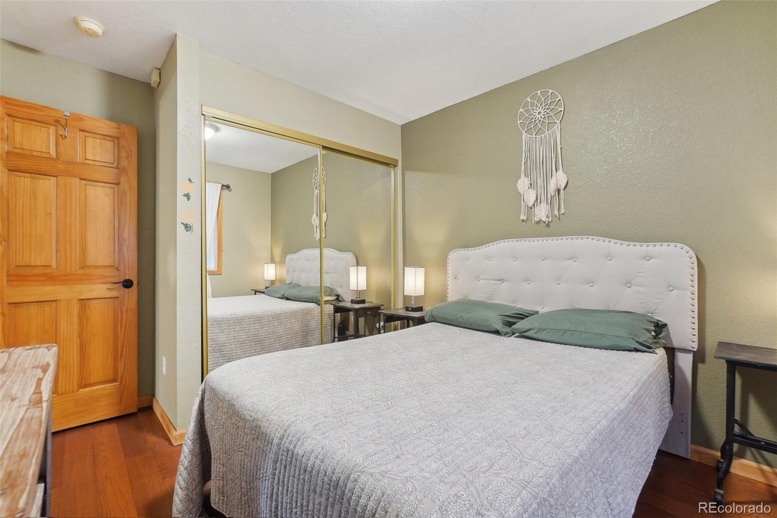 125 Aspen Road Black Hawk, CO 80422 - Photo 13 of 44 a bedroom with a bed and wooden floor