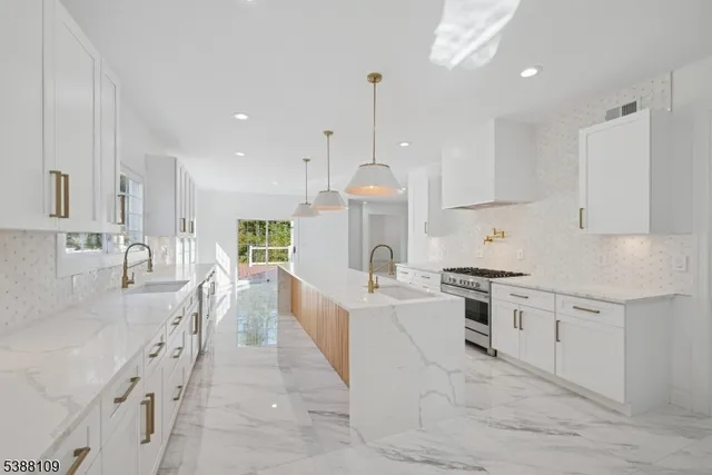 a large white kitchen with granite countertop lots of counter top space