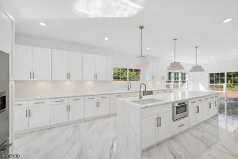 a kitchen with granite countertop white cabinets and white appliances