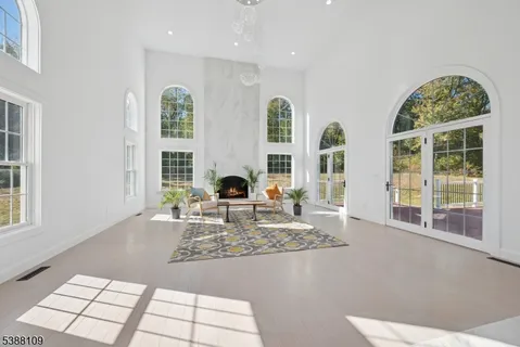 a living room with fireplace furniture and a large window